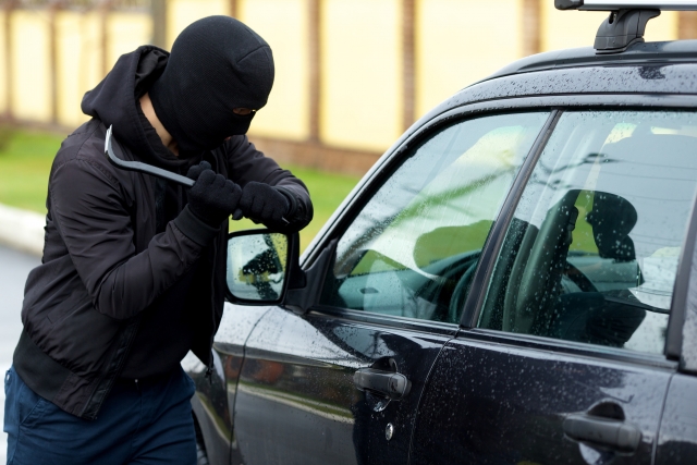 車の窓ガラスを割る泥棒
